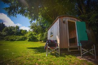 Wooden shepherds hut on an open grass field