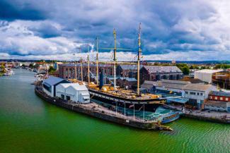 Large boat with masts in a harbour