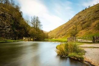 Lake with stepping stones surrounded by grassy hills