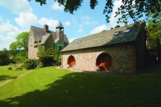 Stone buildings surrounded by grass and trees