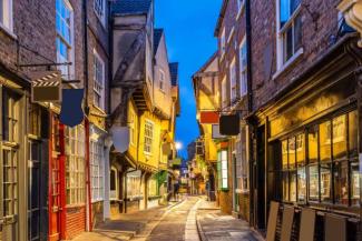 Historic street with different sized shops leaning out into the path