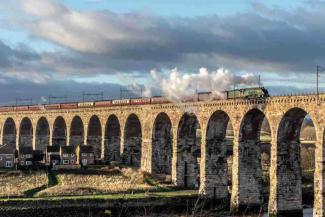 Steam train travelling across a bridge