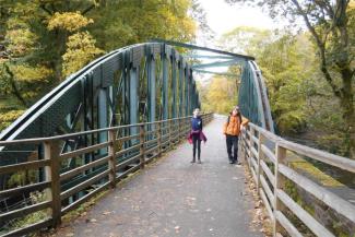 Two children crossing a metal bridge