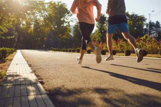 A man and a woman in sportswear are running along the city street in the morning. Runners are running in the city..Jogging. Health. Healthy lifestyle.