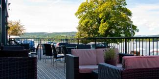 Veranda with outdoor seating overlooking a large lake and trees