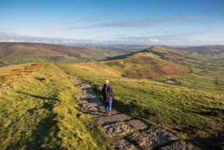 Woman walking on a path in the Peak District countryside