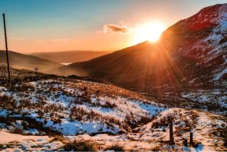 Snow covered ground in winter at sunrise