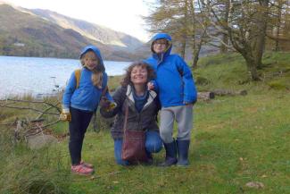 Mother smiling with her two children by a lake