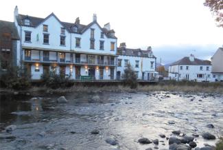 River running past a white hostel building