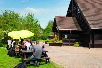 Guests sat outside on a sunny day at YHA London Lee Valley