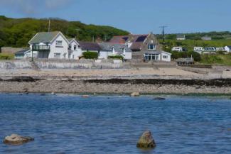 Exterior of YHA Port Eynon White painted hostel building by the sea