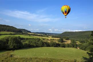 Hot air balloon flying over Yorkshire Dales on a sunny day