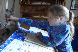 Young girl writing with a quill