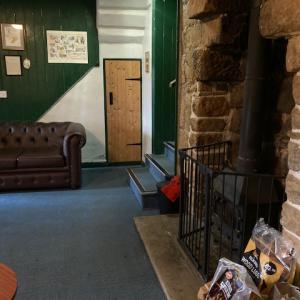 YHA Mankinholes lounge area with sofa and fireplace