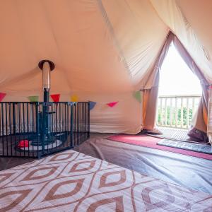 YHA Eden Project premium bell tent interior with log burner