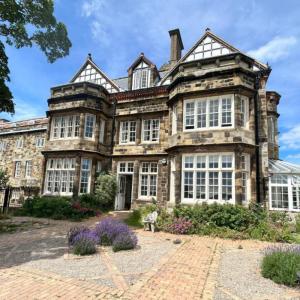 Large mansion building with stone walls and white wooden window frames