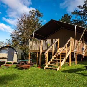 Safari tent and Landpod on a grass field