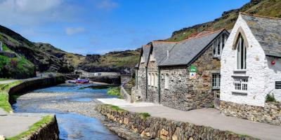 Stone hostel building by a river estuary with a blue sky in the background