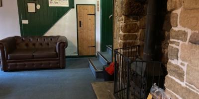 YHA Mankinholes lounge area with sofa and fireplace