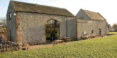 Grey stone building surrounded by grass