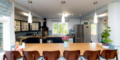 Open plan kitchen containing three hanging lights and a breakfast bar with six chairs