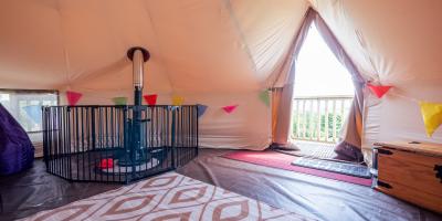 YHA Eden Project premium bell tent interior with log burner