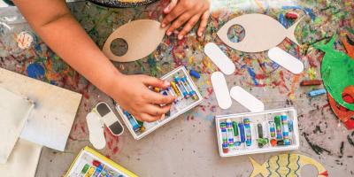 Child painting wooden fish