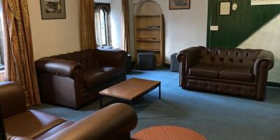 YHA Mankinholes Lounge area with sofa and fireplace