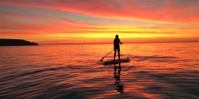 Person on a paddleboard at sunset