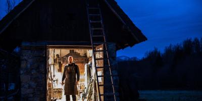 Blacksmith in rural forge, at twilight