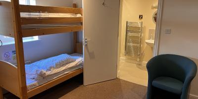 Bedroom with a set of bunk beds and open door into an en-suite bathroom