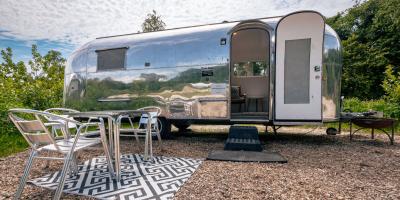 Silver caravan with open door and metal seating