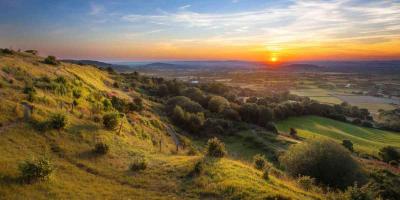 Autumn sunrise over rolling green hills