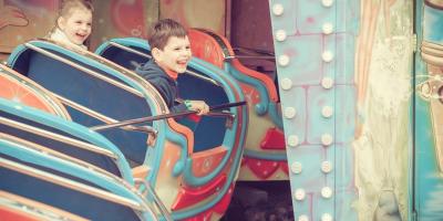 Children riding a rollercoaster at a theme park