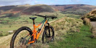 Orange bike in a field with a view of the countryside in the background