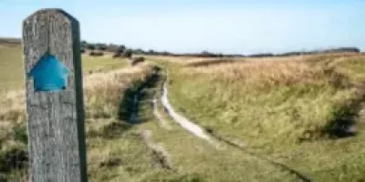 Bridleway sign marked with a blue arrow.