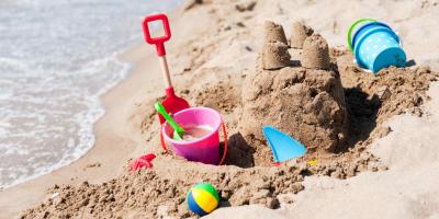 Bucket and spade next to a sandcastle on the beach