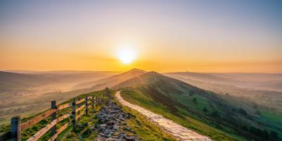 Stone footpath and wooden fence leading a long The Great Ridge in Castleton