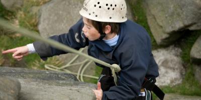 Boy abseiling down a rock face