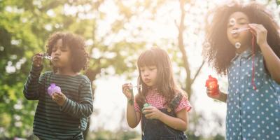 Children blowing bubbles on a sunny day