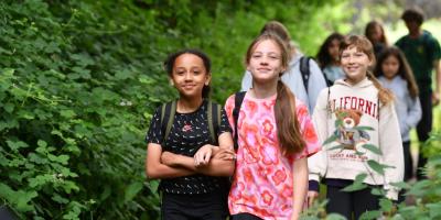 Group of smiling children walking through woodland