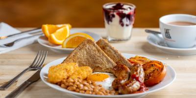 Full English breakfast with orange slices and fruit yogurt on the side