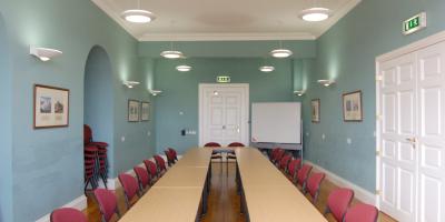 Room with blue painted walls and tables surrounded by red chairs