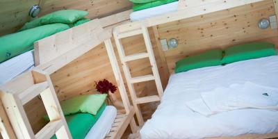 Inside a wooden cabin with a double bed and bunks