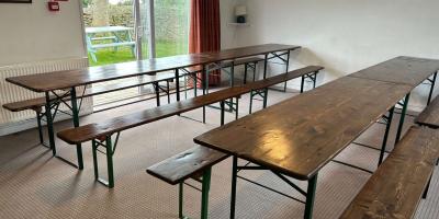 Dining room with white painted walls and long wooden tables with benches