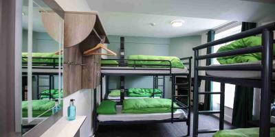 Large bedroom with bunk beds and a mirror over a washbasin