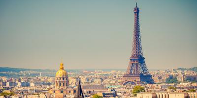 Tall metal tower structure surrounded by buildings