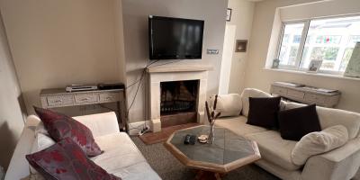 Lounge with two sofas, a fireplace and a wall-mounted TV