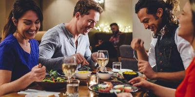 Group of four adults eating at a table in a restaurant