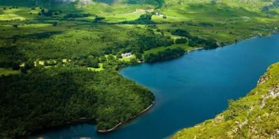 Aerial view of a large blue lake surrounded by trees and countryside